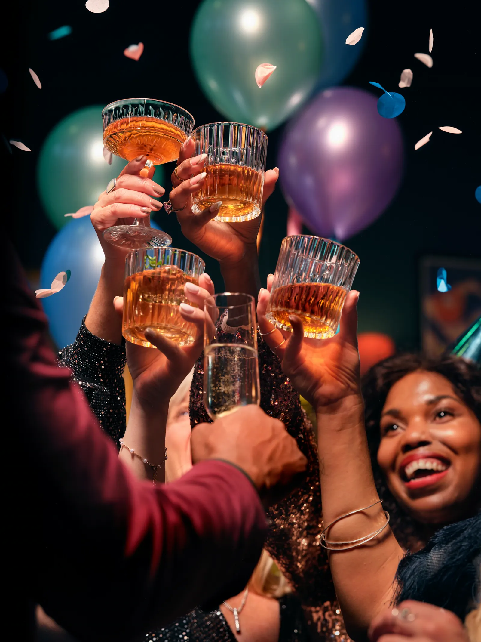 Friends holding their glasses up together.
