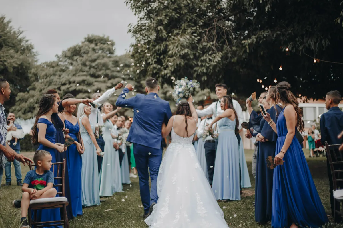 Guests in white dancing together on a stretch of grass.